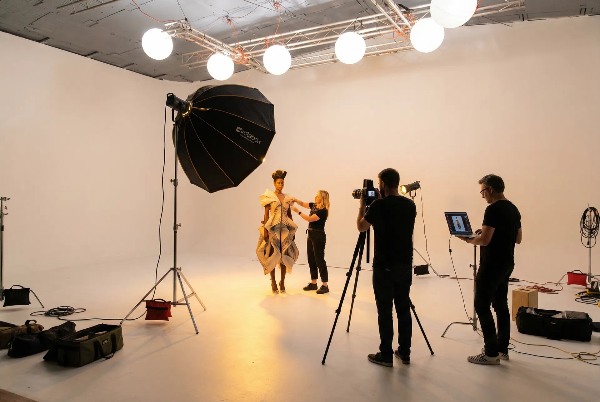 Fashion editorial shoot under globe balloons with sculptural gown