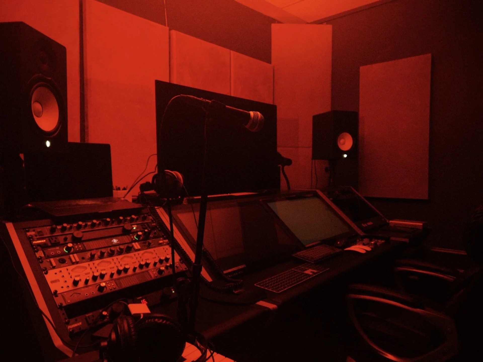Recording studio control room under red lighting